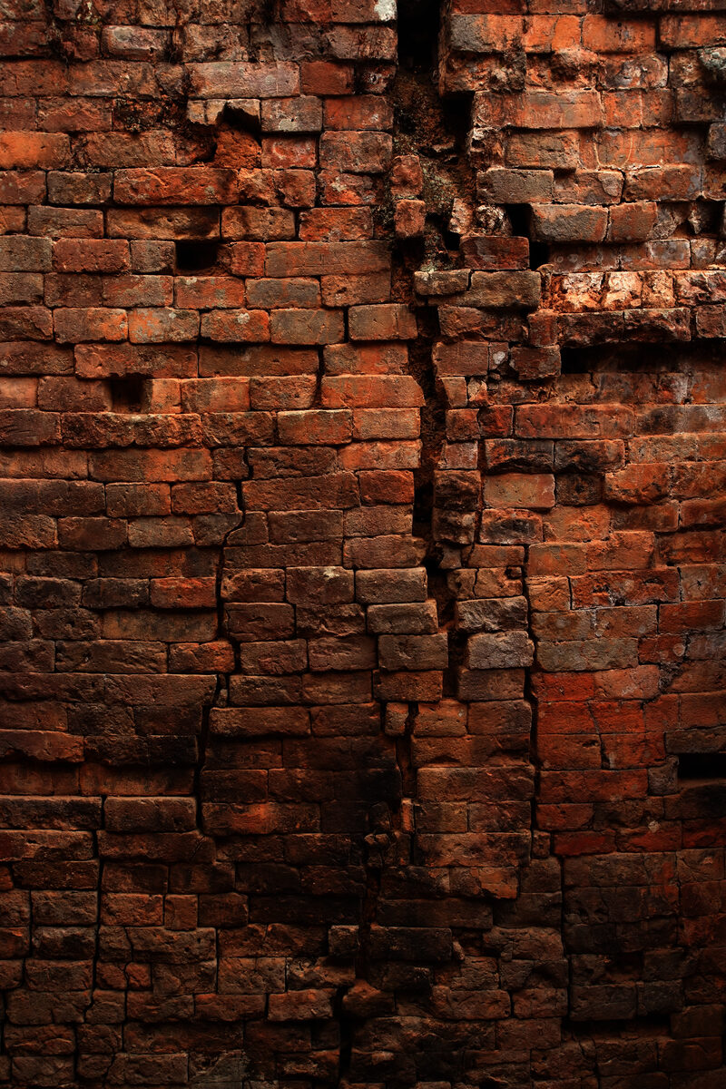 Deteriorated historic brick wall showing damage requiring restoration